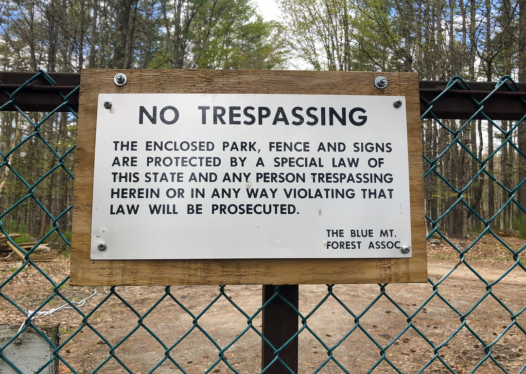 Sign reading "NO TRESPASSING: THE ENCLOSED PARK, FENCE AND SIGNS ARE PROTECTED BY A SPECIAL LAW OF THIS STATE AND ANY PERSON TRESPASSING HEREIN OR IN ANY WAY VIOLATING THAT LAW WILL BE PROSECUTED.  THE BLUE MT. FOREST ASSOC"